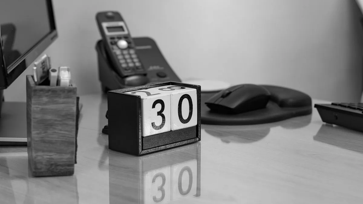 biurko z kalendarzem z kostek, podkładką pod mysz i telefonem